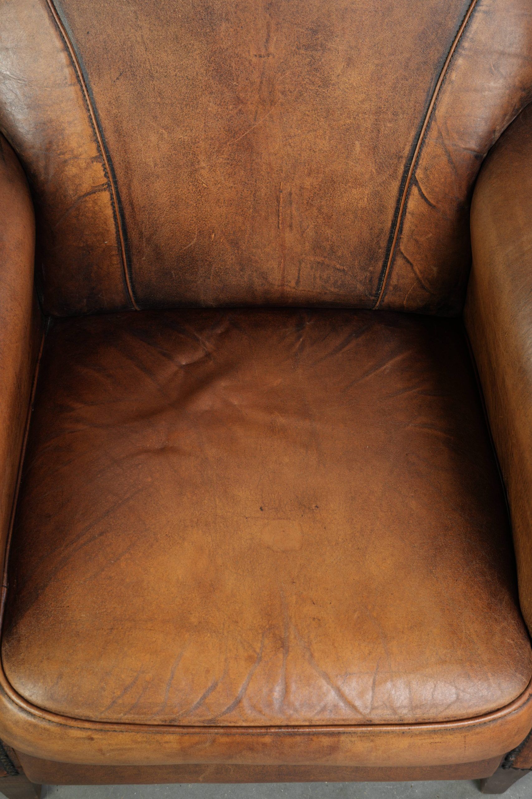 Comfortable characterful sheepskin armchair finished with decorative nails
