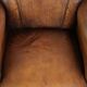 Comfortable characterful sheepskin armchair finished with decorative nails