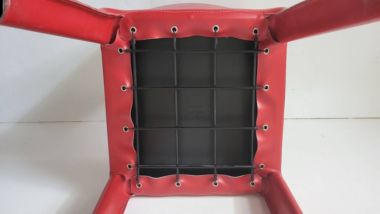 Red leather dining chairs by Arper