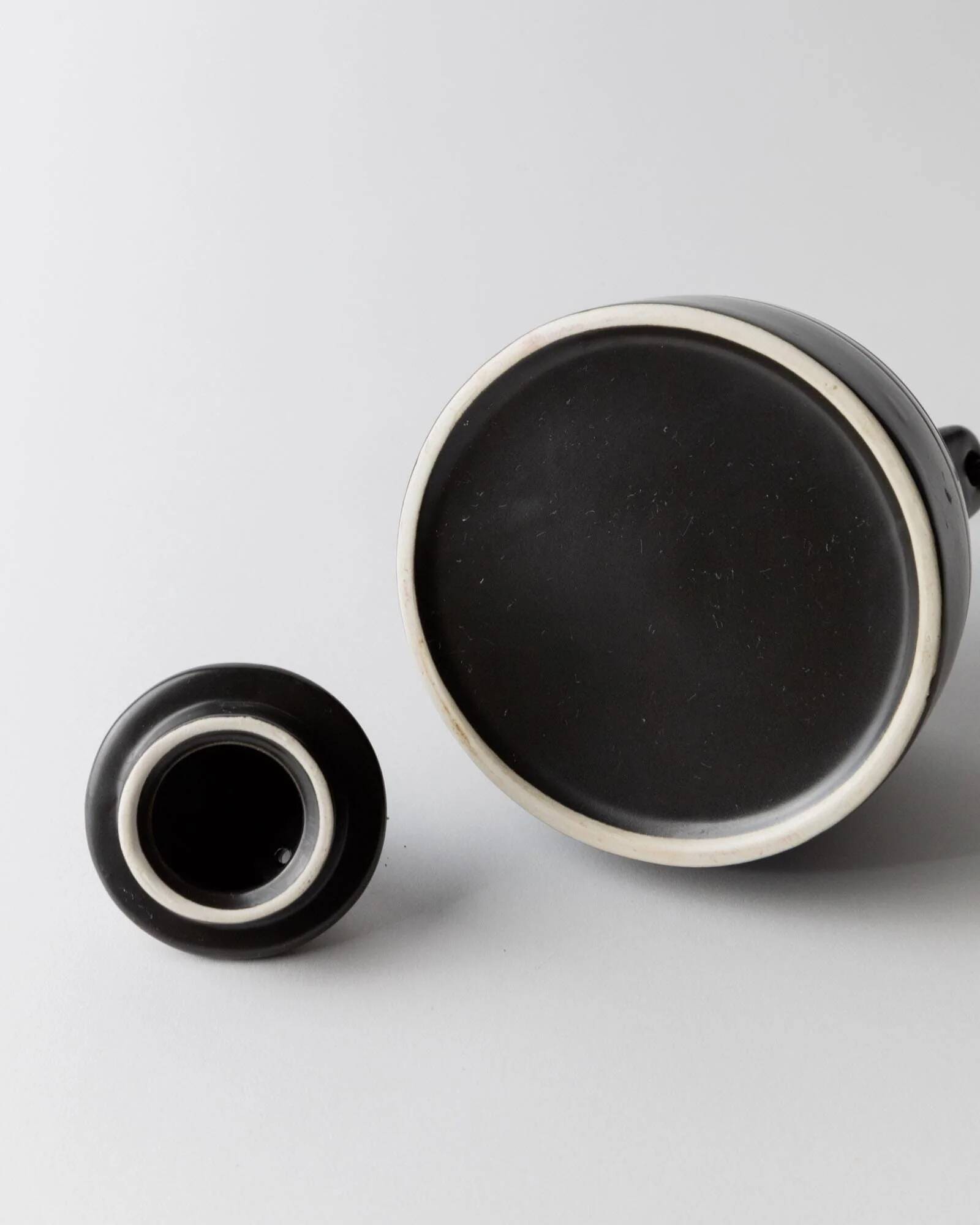 Vintage ceramic teapot from the 1980s, black with white stripes and a metal handle.