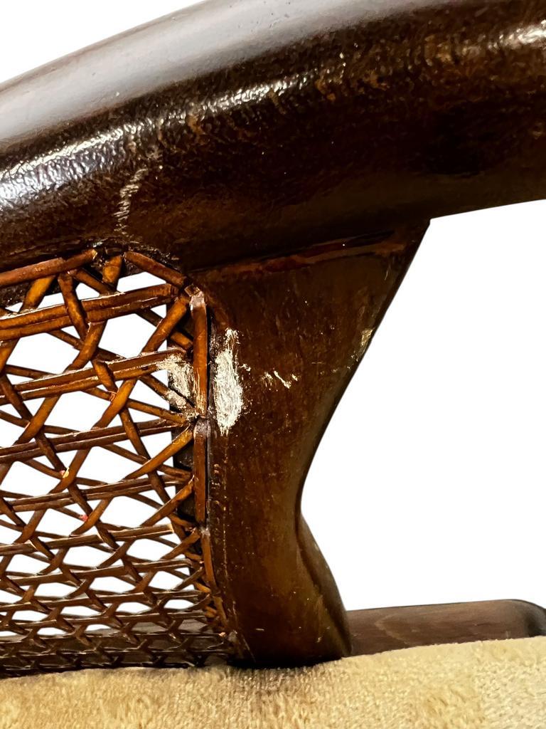 Vintage wooden armchair with rattan weaving.
