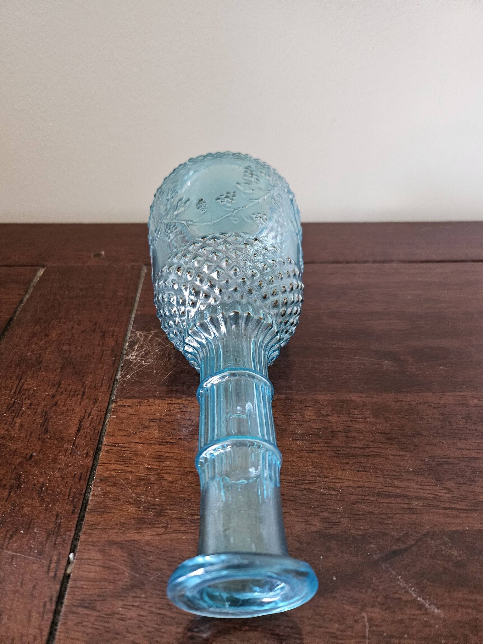 Small vintage turquoise blue glass carafe with floral design.