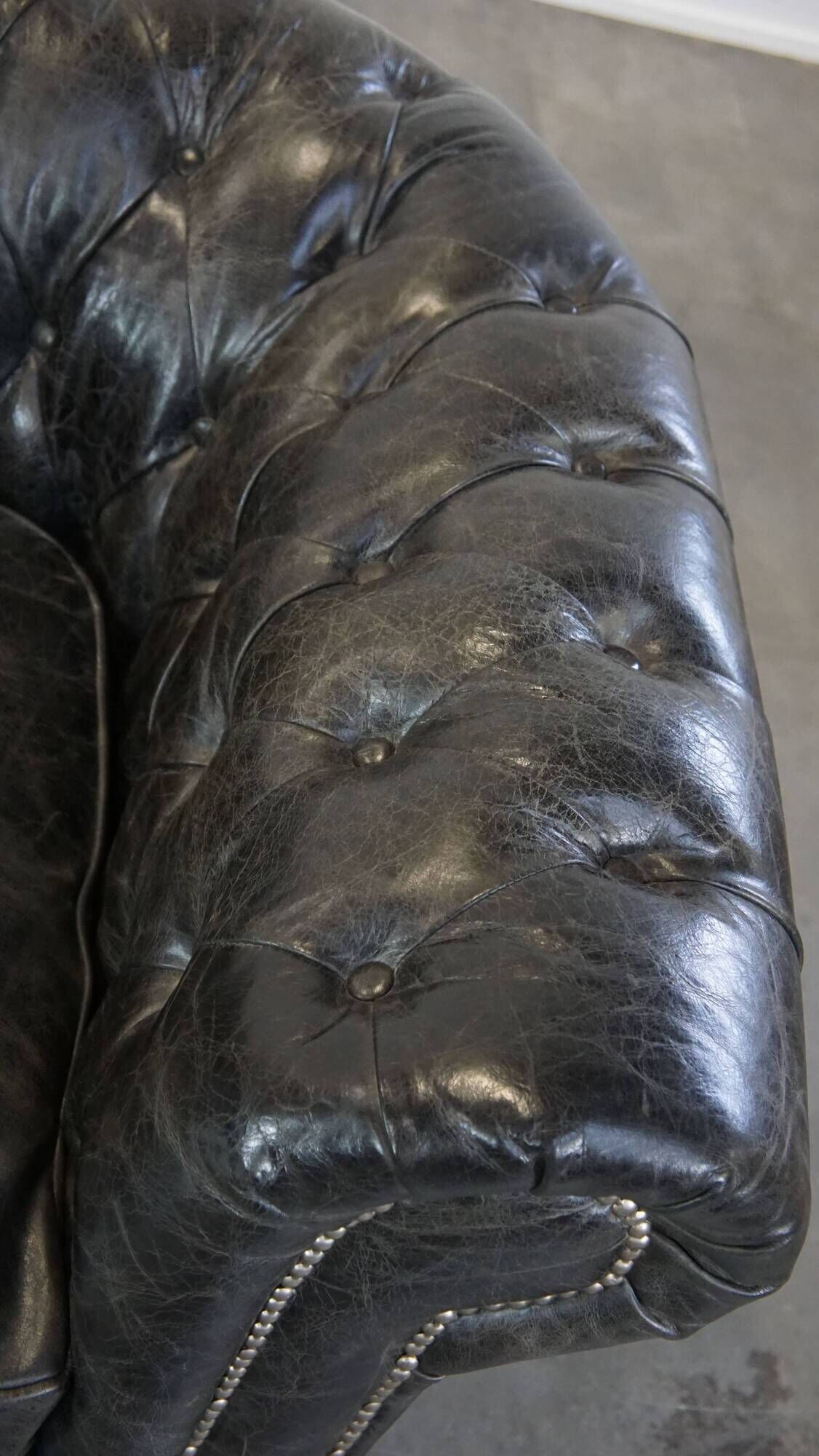 Spacious black cow leather chesterfield armchair with distinctive character