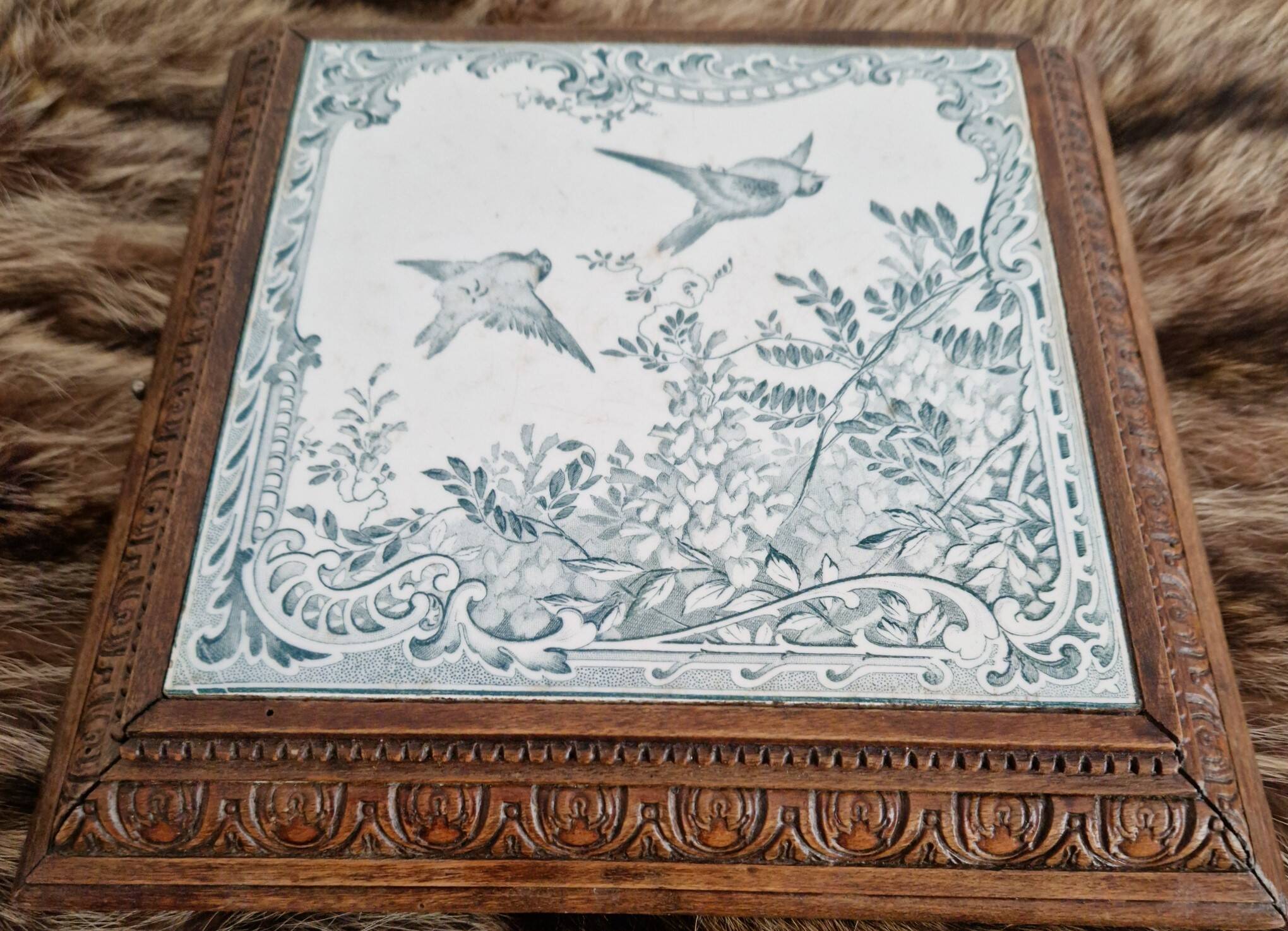 Antique musical trivet made of carved wood and Belle Époque earthenware.