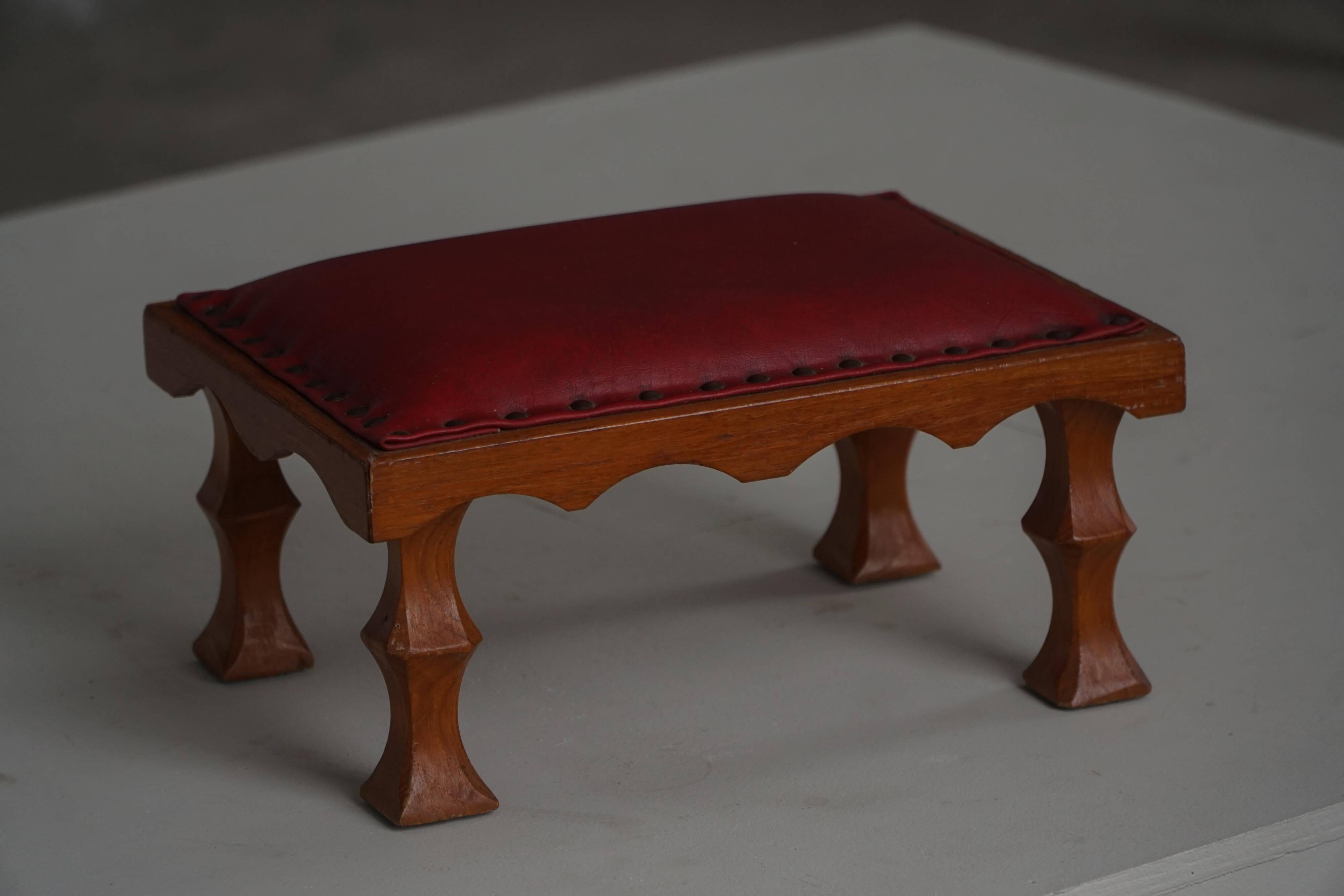 Danish sculpted oak stool from the mid-20th century with a red leather seat, 1950s.
