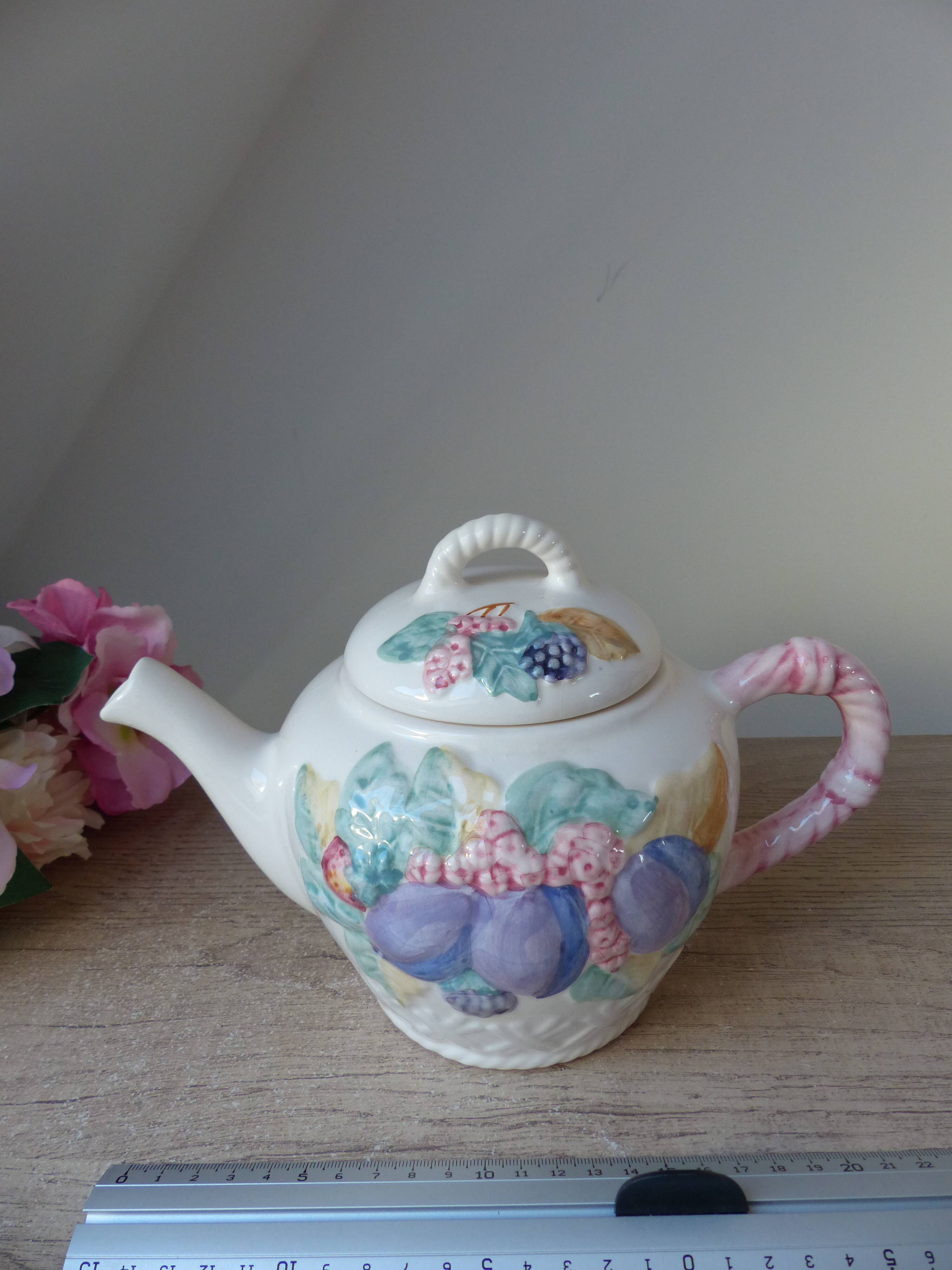Old ceramic teapot in the shape of a basket of fruits from the garden