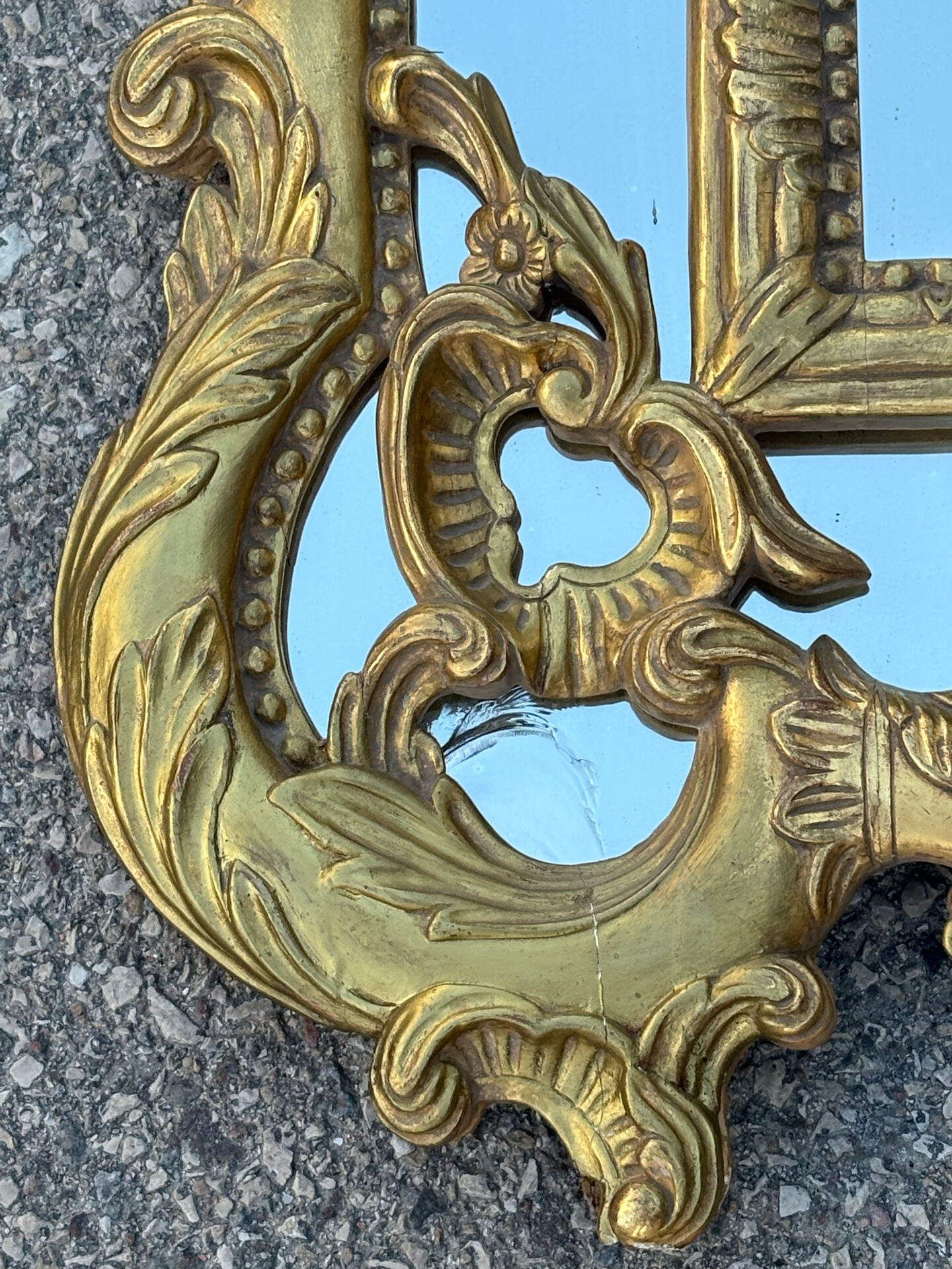 Large mirror with carved and gilded wooden frame, in Regency style.