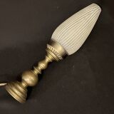 Old bronze or brass table lamp from the early 20th century with white streaked flame glass globe