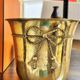 Pair of brass plant pots, decorated with cord and tassels.
