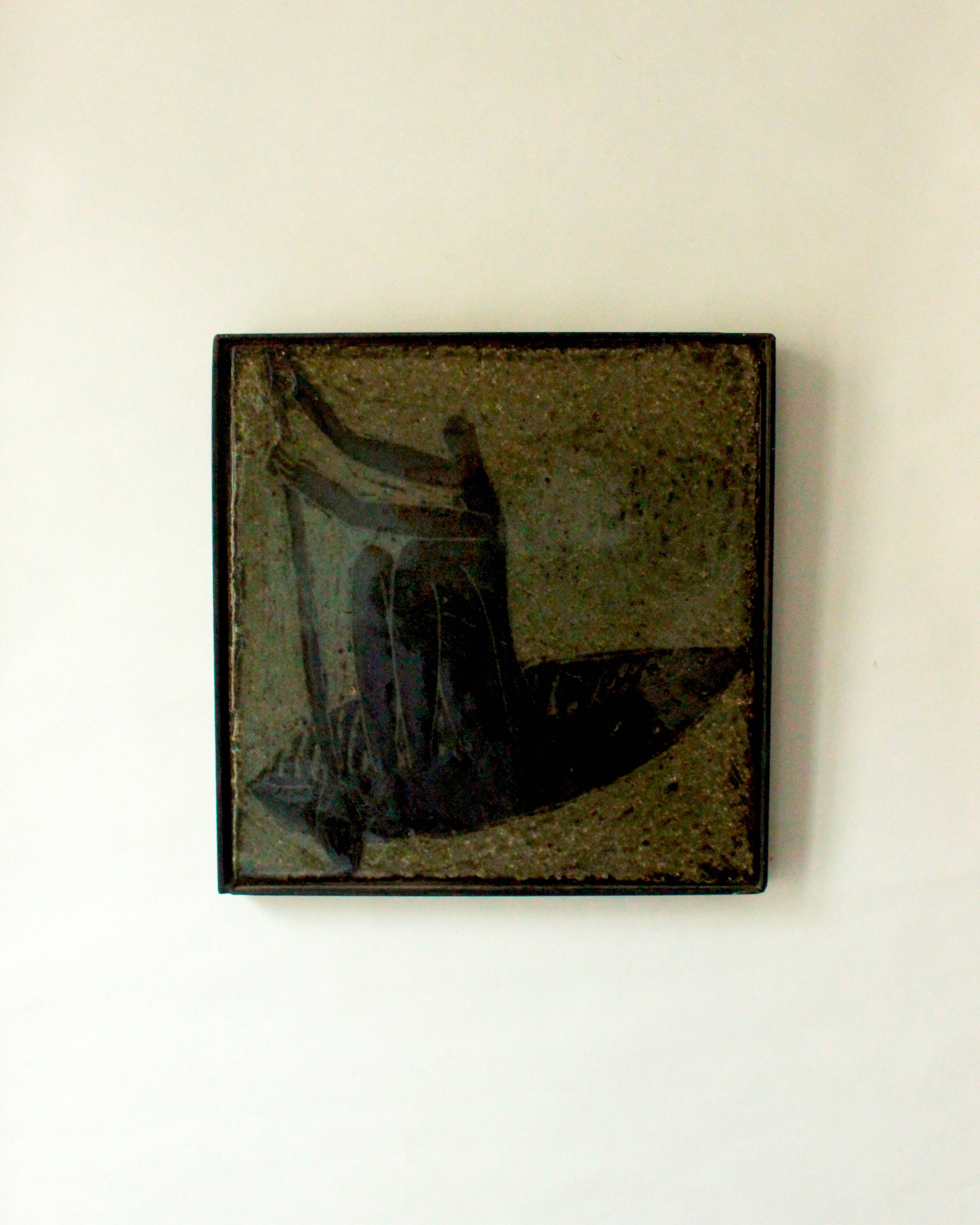 Glazed chamotte clay plaque in grey-green and black, decorated with a rower.