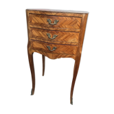 Antique storage furniture with ornaments and a marble top.