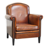 Sheepskin leather armchair in a cognac color with black piping