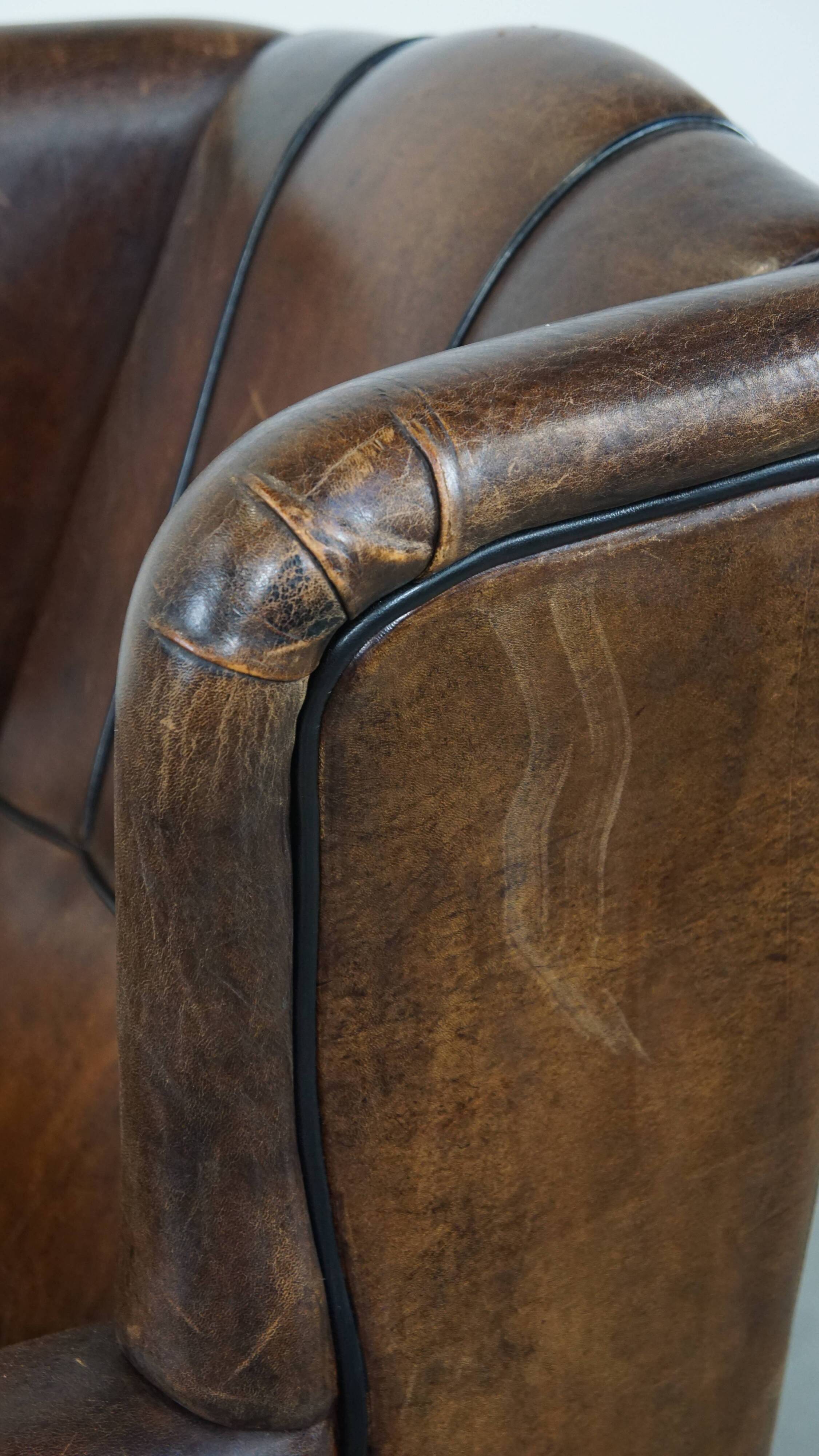 Vintage sheepskin wingback chair finished with black piping