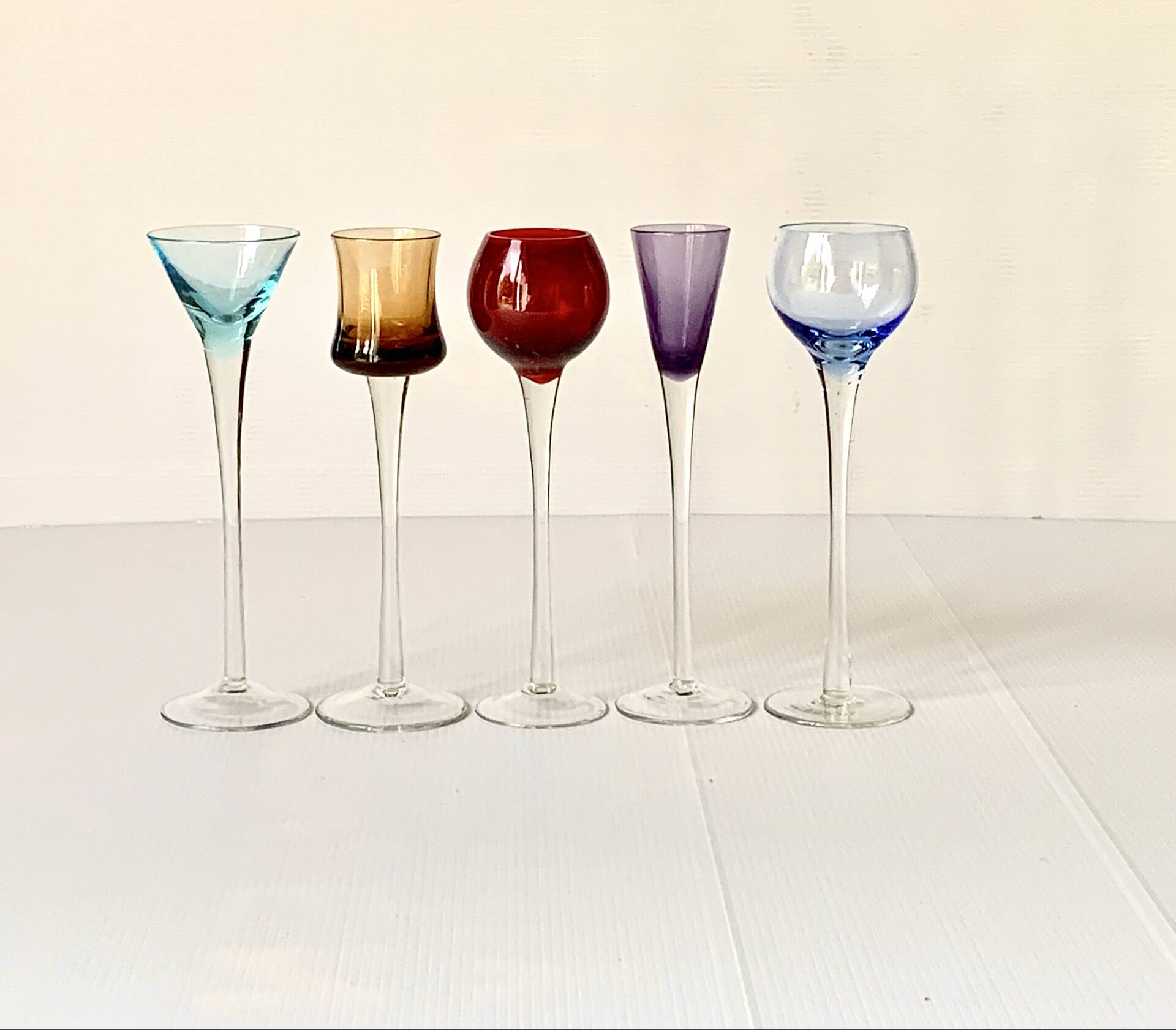 Cinq verres à liqueur colorés sur pied