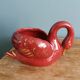 Poet Laval swan hides zoomorphic pot in burgundy ceramic.