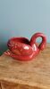 Poet Laval swan hides zoomorphic pot in burgundy ceramic.