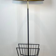Designer floor lamp in black lacquered metal and brass, incorporating a magazine rack