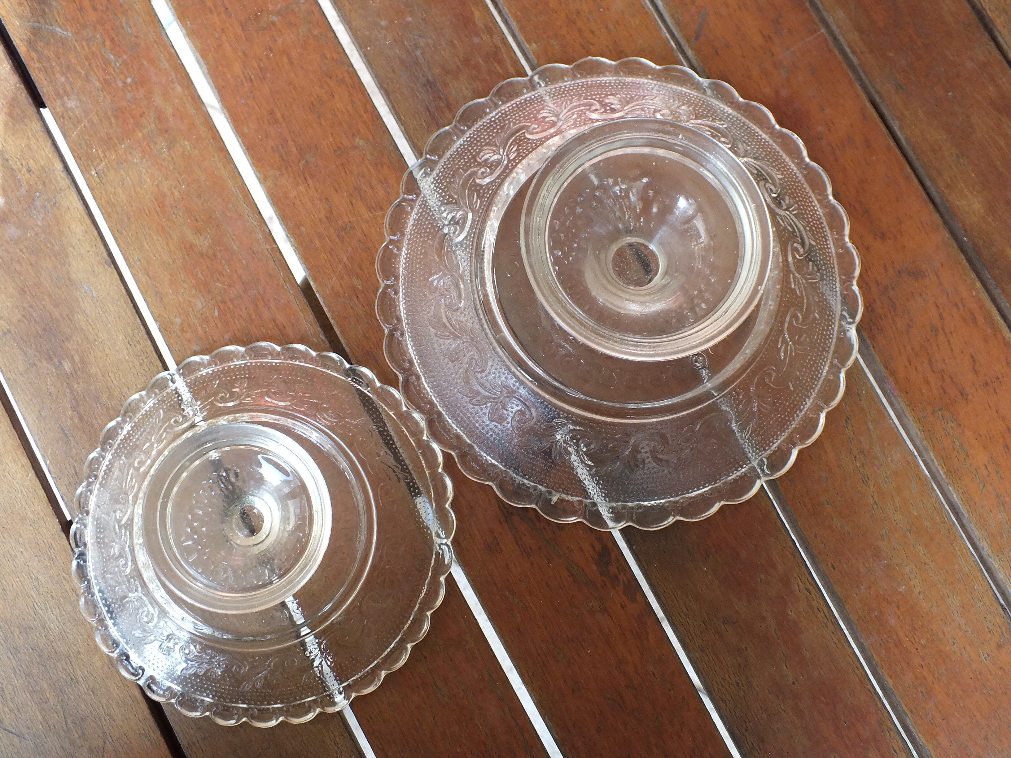 Duo of molded glass display cups, arabesque décor