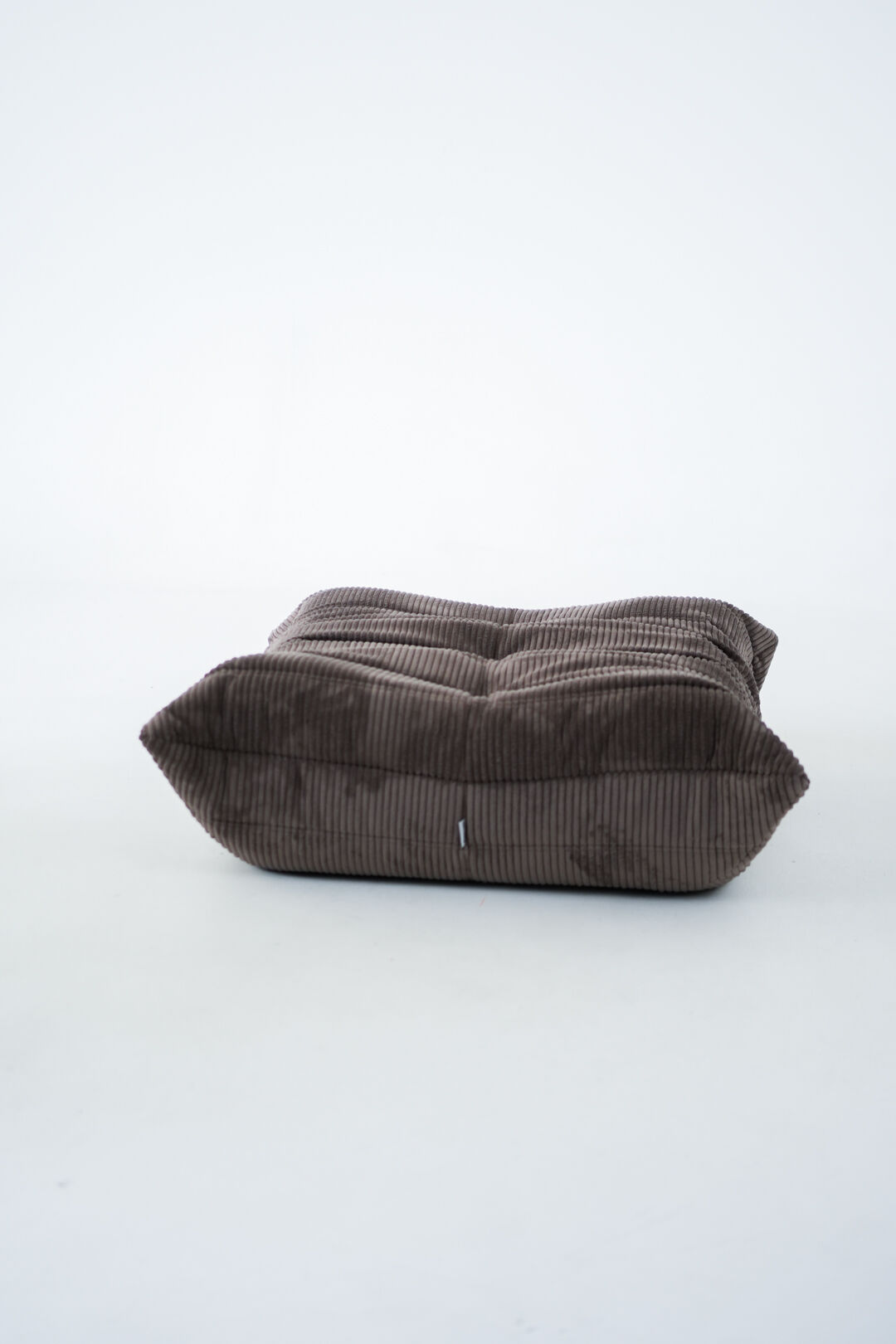Ensemble de chaise et pouf Togo en velours côtelé marron.