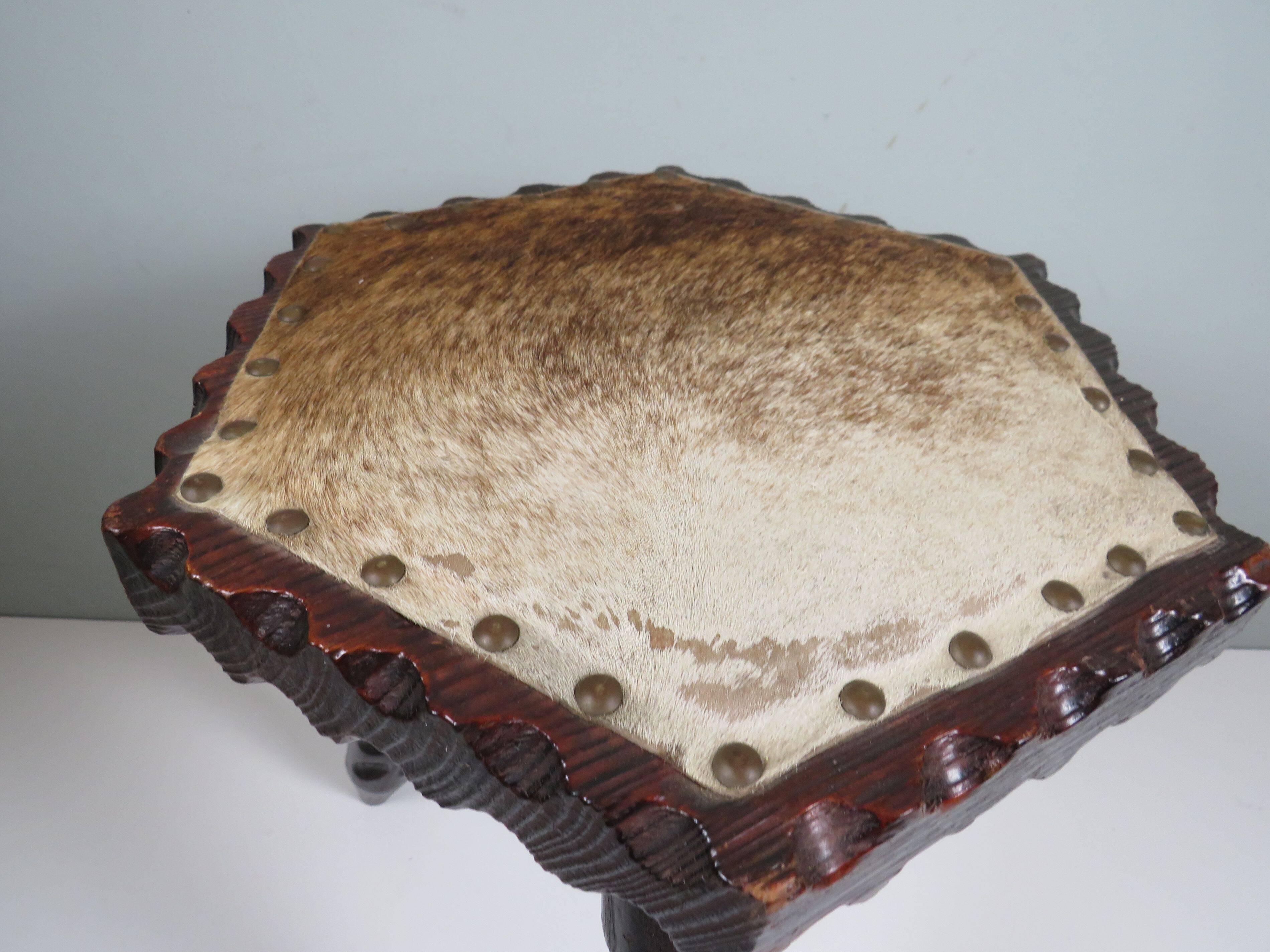 Vintage Spanish stool in carved wood with a leather seat.