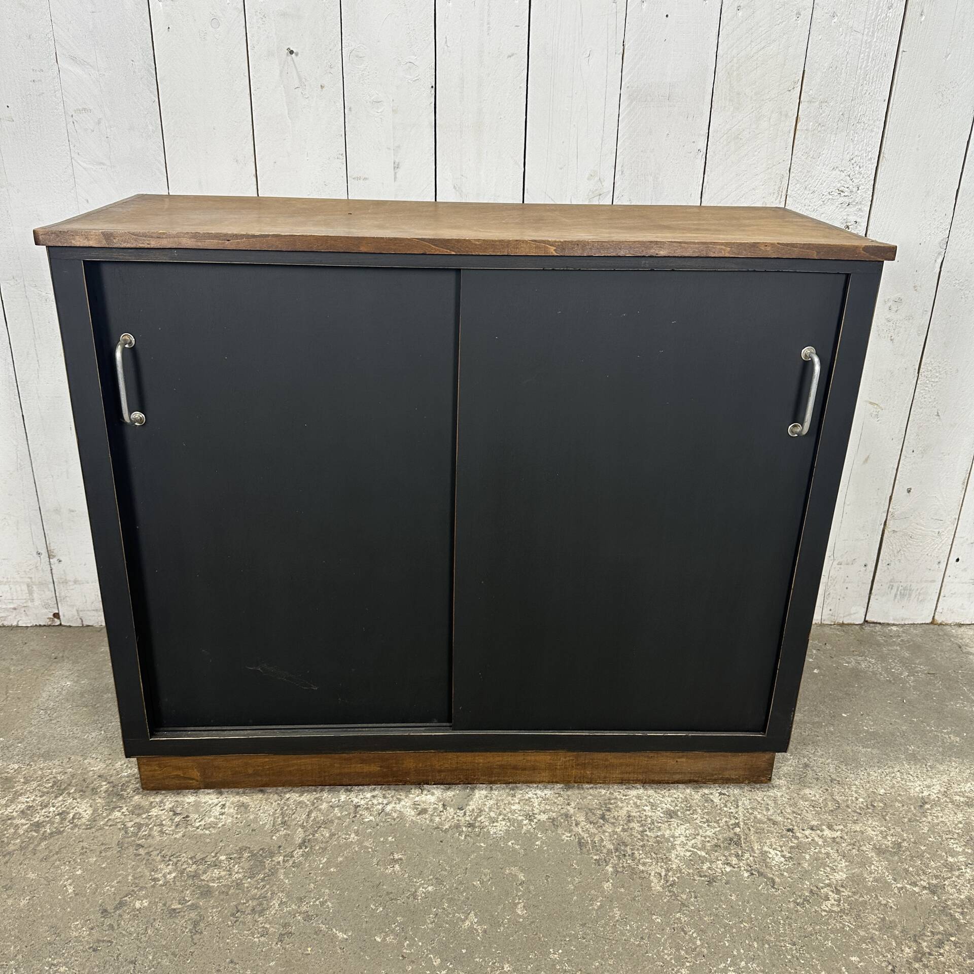 Small vintage black buffet with sliding doors.