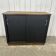 Small vintage black buffet with sliding doors.