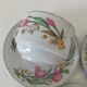 Trio of floral porcelain cups and saucers