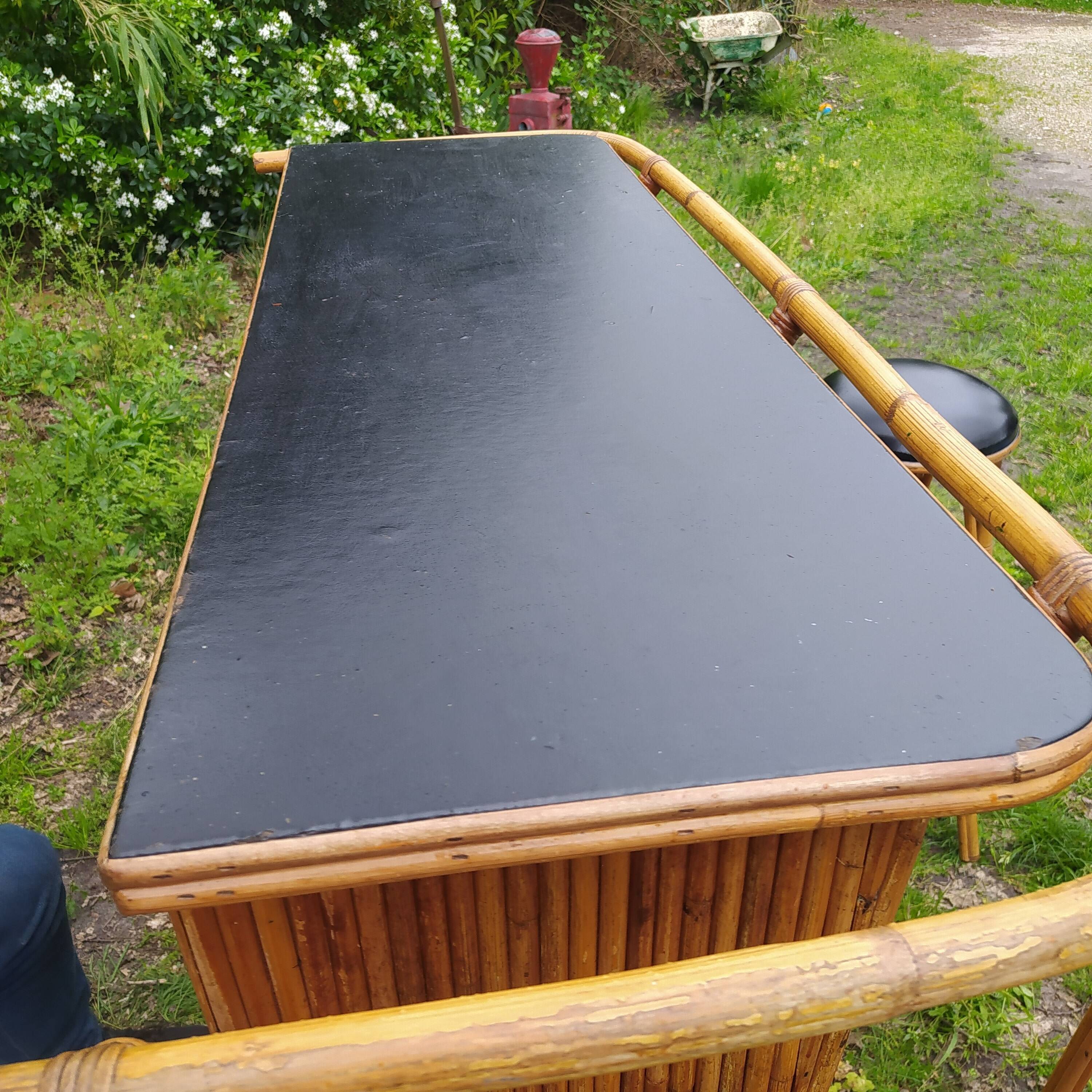 Vintage rattan bar with 1960s earthenware tile decor with 2 stools