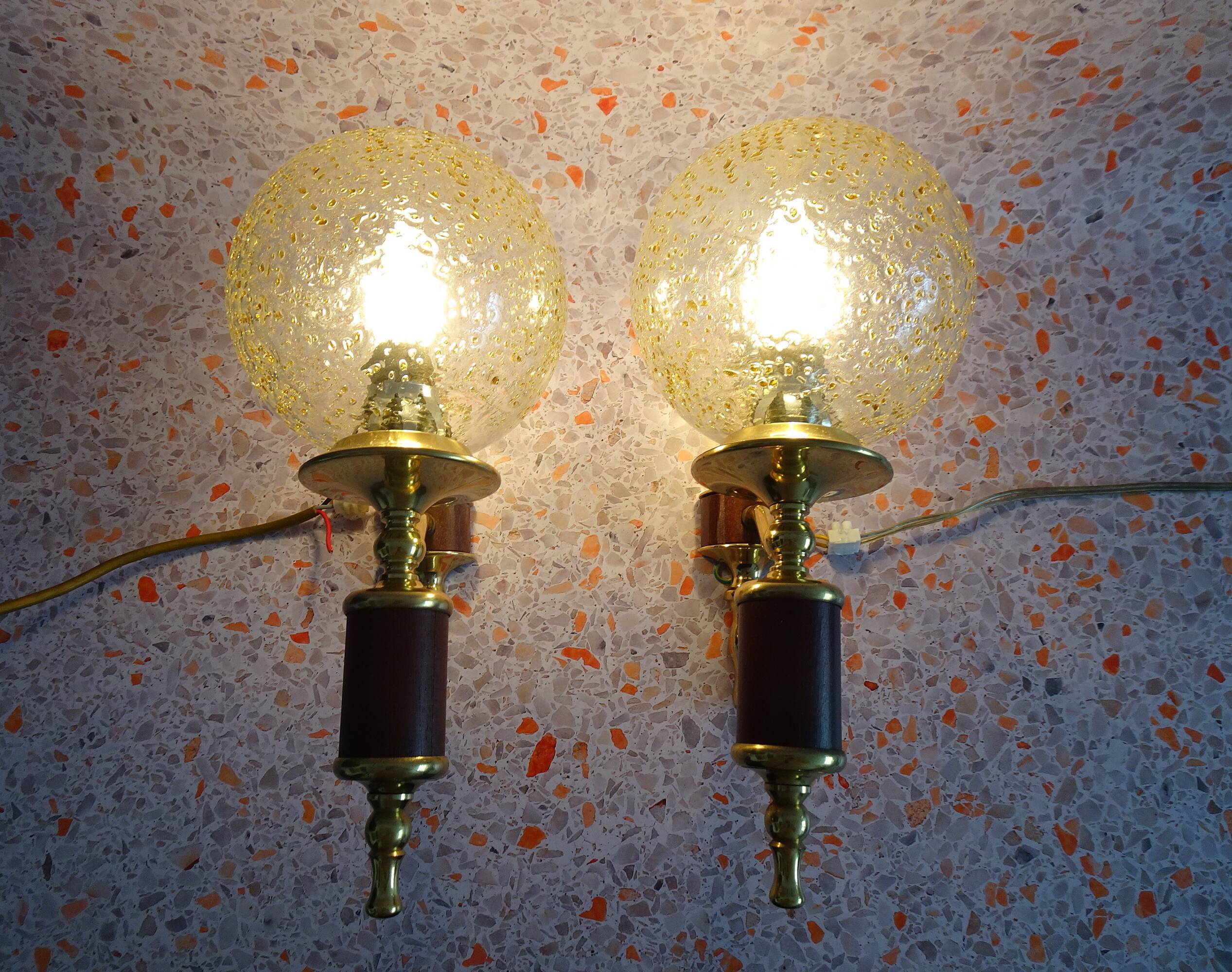 Golden wall lamps with round glass shades and teak veneer