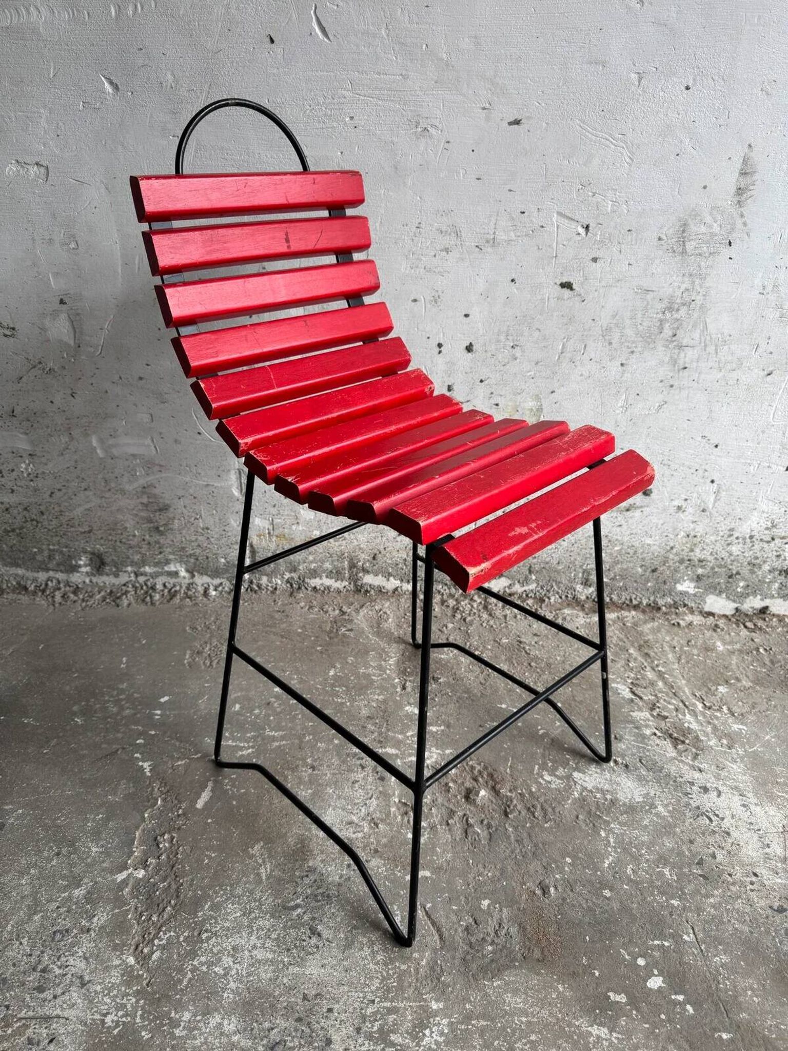 Red slatted chair with a black metal frame.