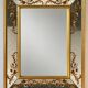 Large Venetian-style mirror with golden floral decoration.