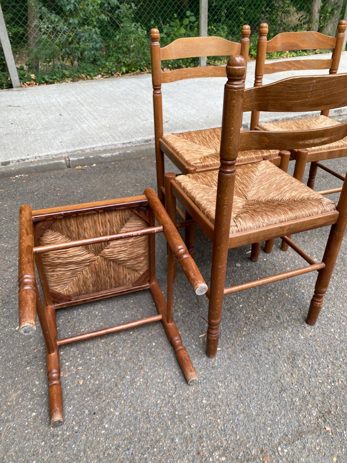 4 solid wood kitchen chairs with straw seats in a country farmhouse style.