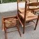 4 solid wood kitchen chairs with straw seats in a country farmhouse style.
