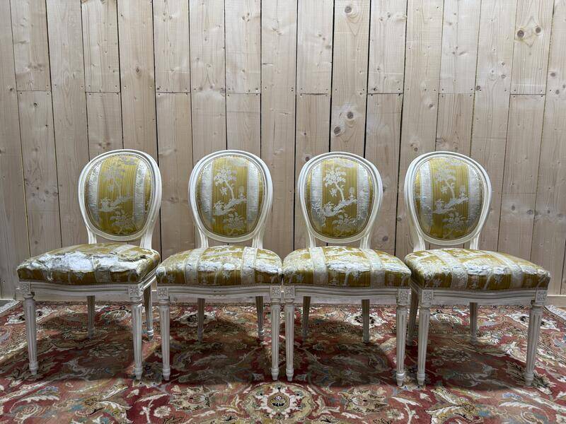 Suite de 4 chaises médaillons de style Louis XVI rechampi blanc cassé