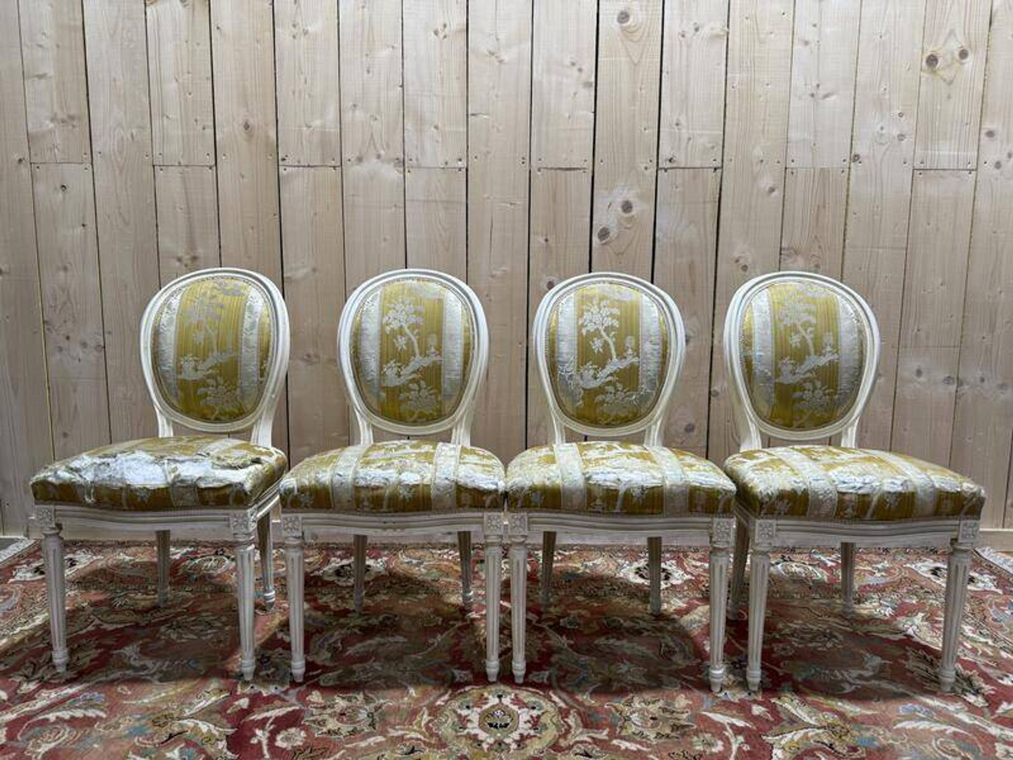 Suite de 4 chaises médaillons de style Louis XVI rechampi blanc cassé