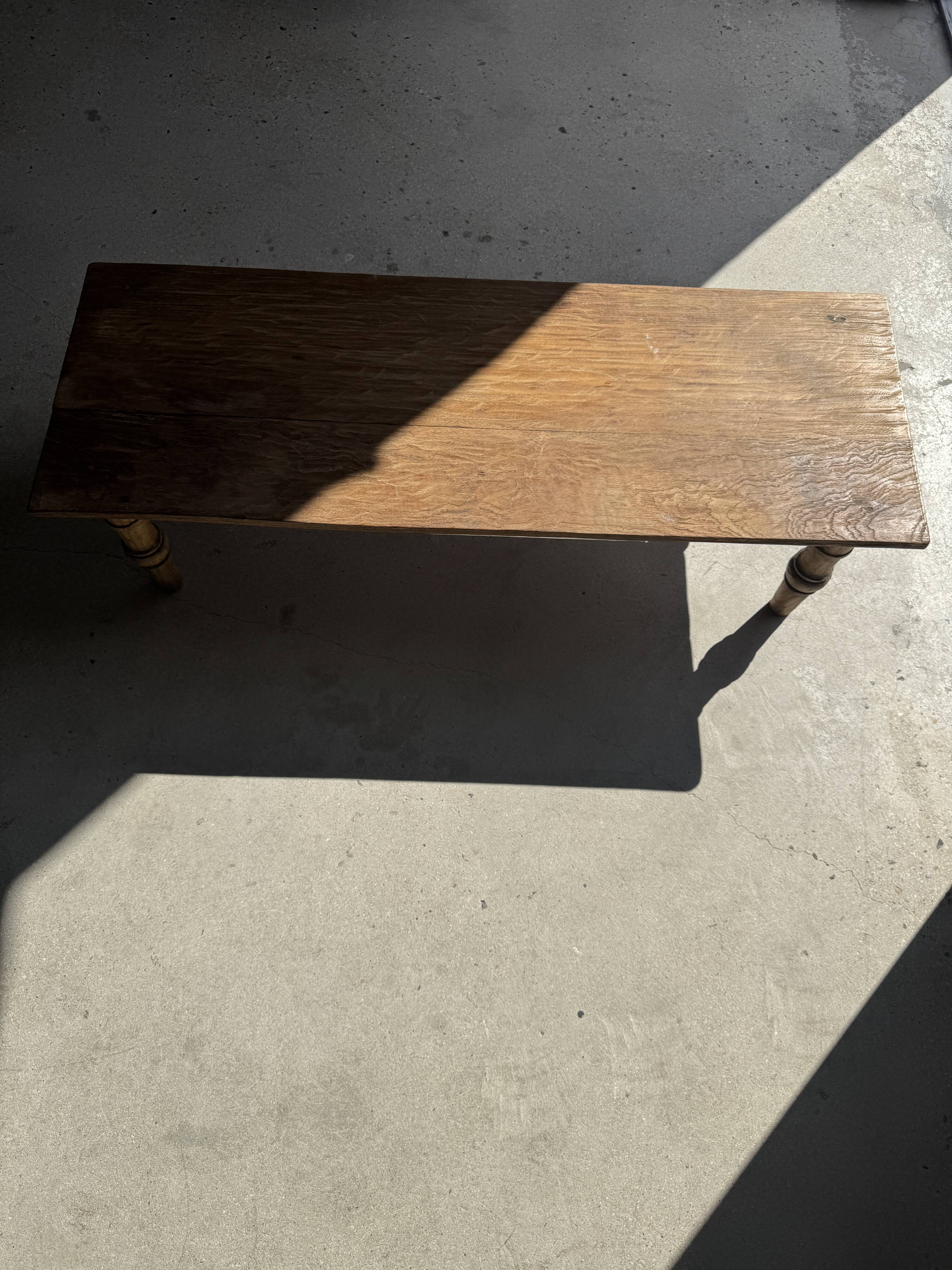 Brown Indonesian teak coffee table, with a border and cylindrical legs H40 L103.