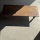 Brown Indonesian teak coffee table, with a border and cylindrical legs H40 L103.