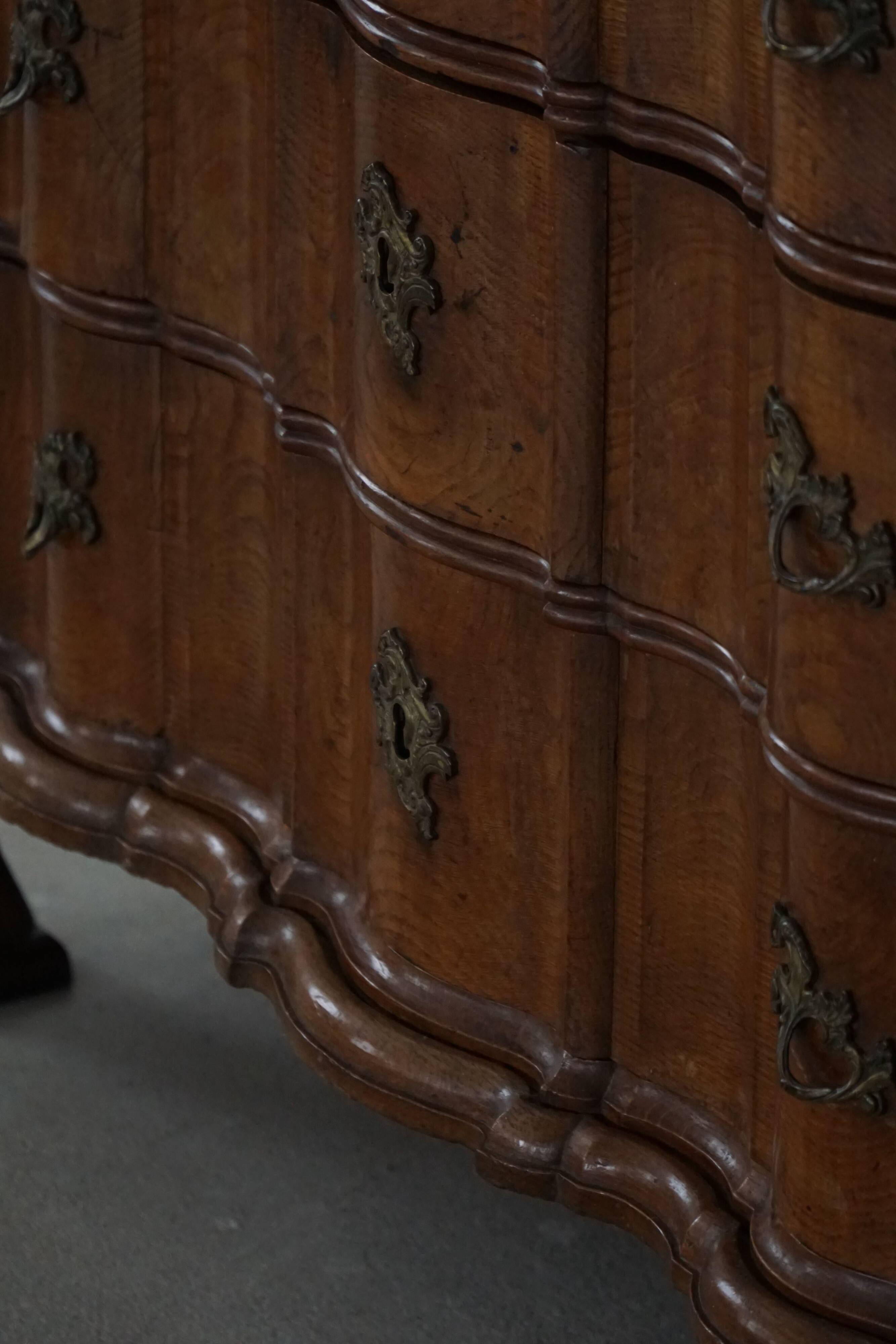 Antique baroque oak commode from the late 18th century with cabriole legs.