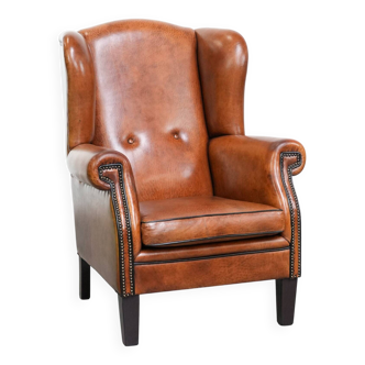 Wingback chair made of sheep leather with black piping in good condition