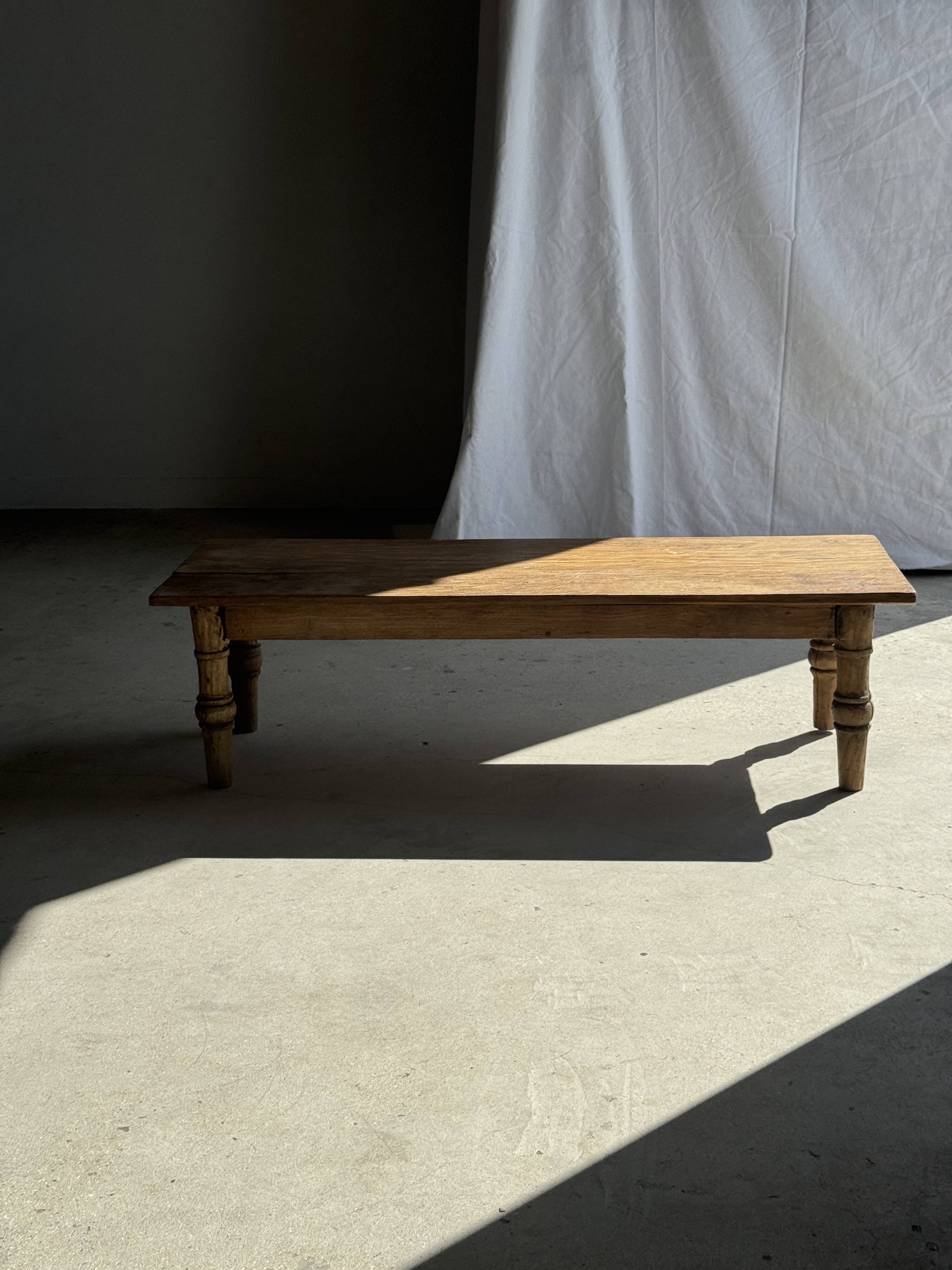 Brown Indonesian teak coffee table, with a border and cylindrical legs H40 L103.