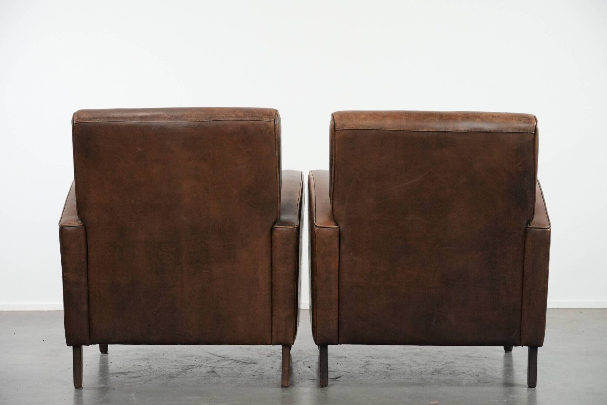 Elegant set of two sheepskin leather armchairs with beautiful round shapes