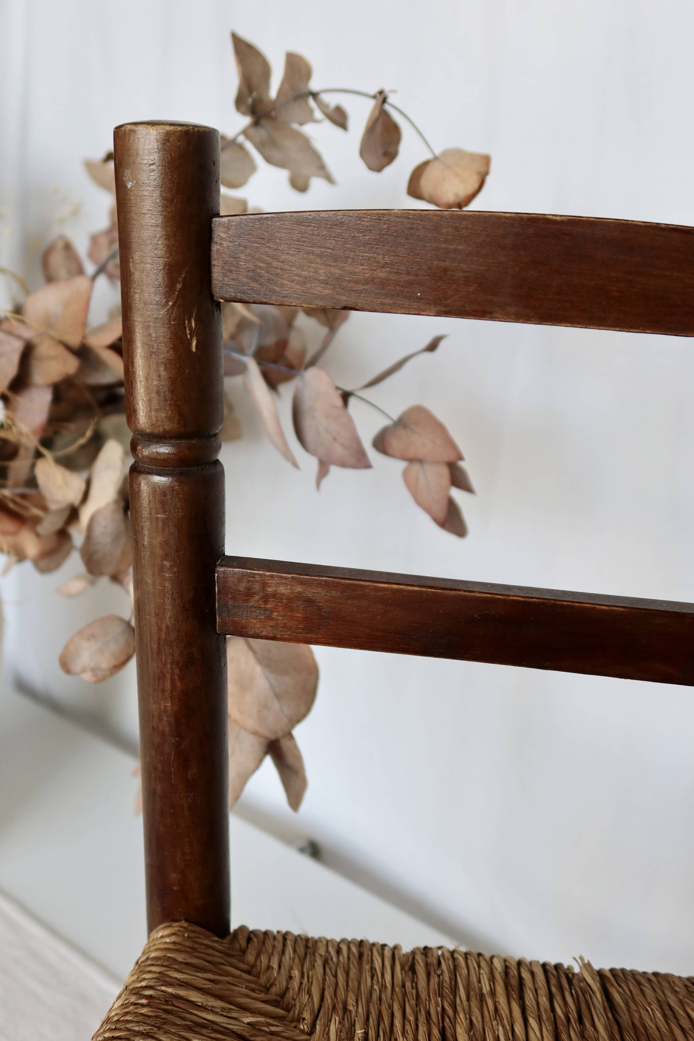 Vintage children's chair in dark wood with woven straw seat