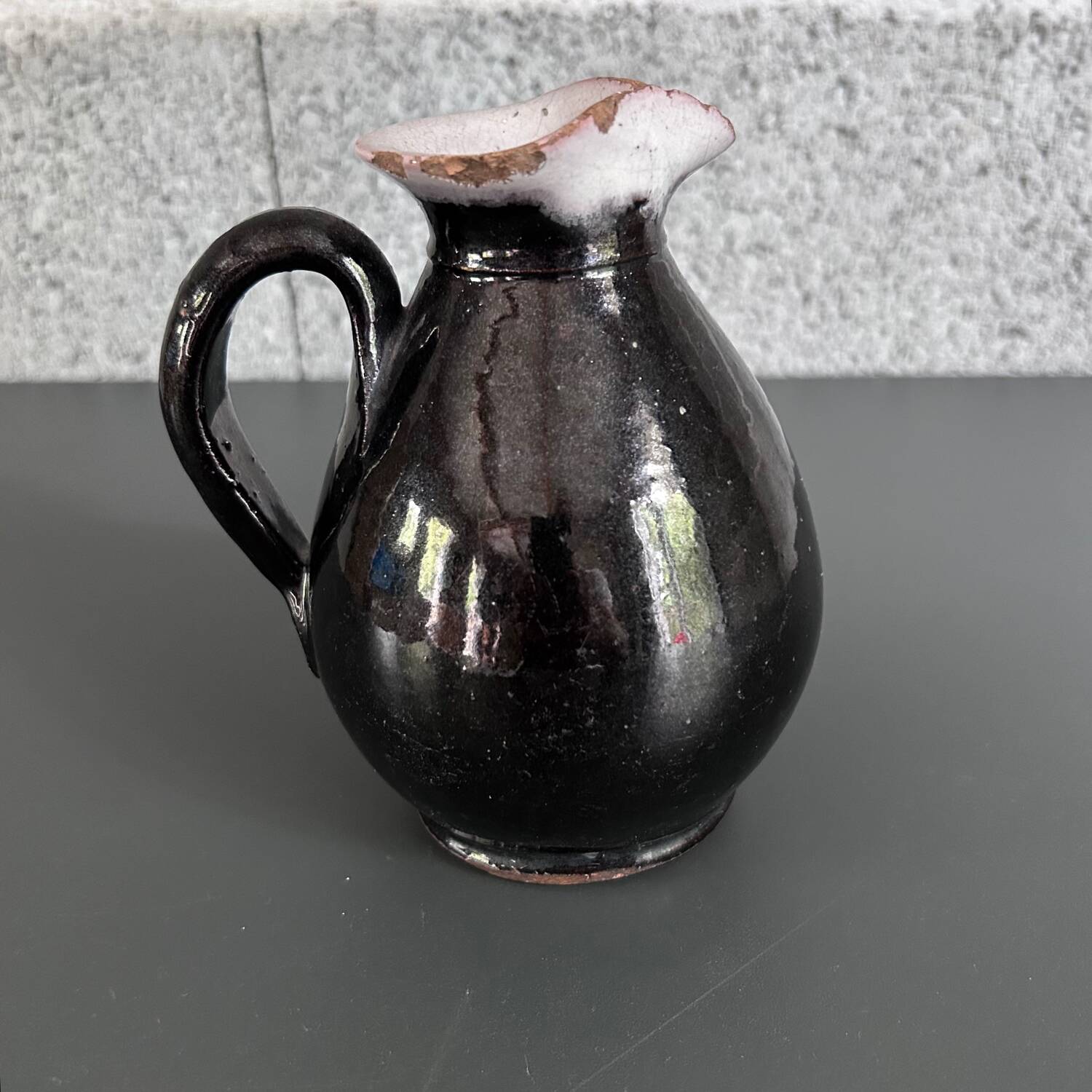 Antique black pitcher with white collar