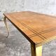 Table basse vintage avec pieds dorés et plateau incrusté de motifs géométriques en placage de bois brun clair