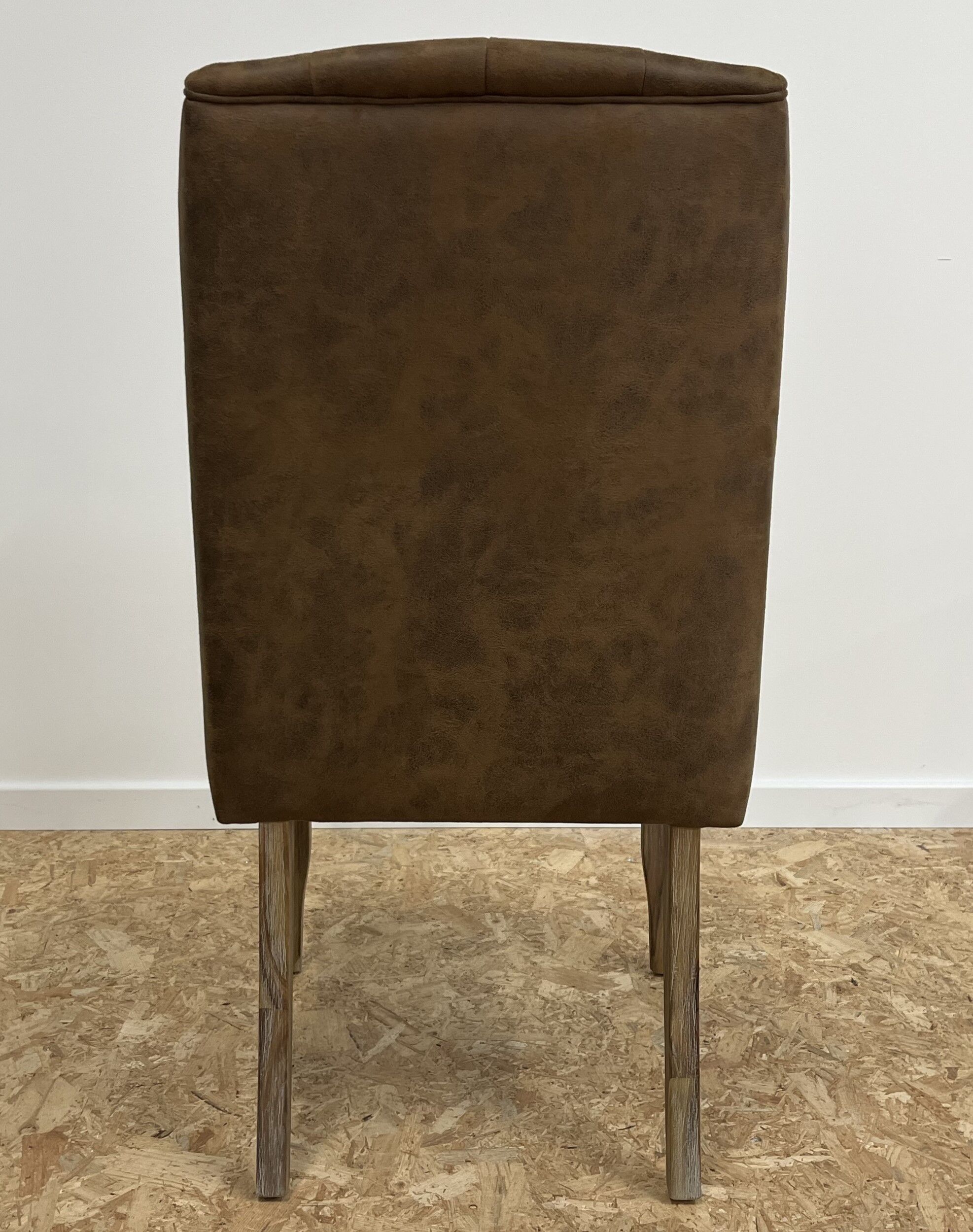 Upholstered armchair in brown imitation leather