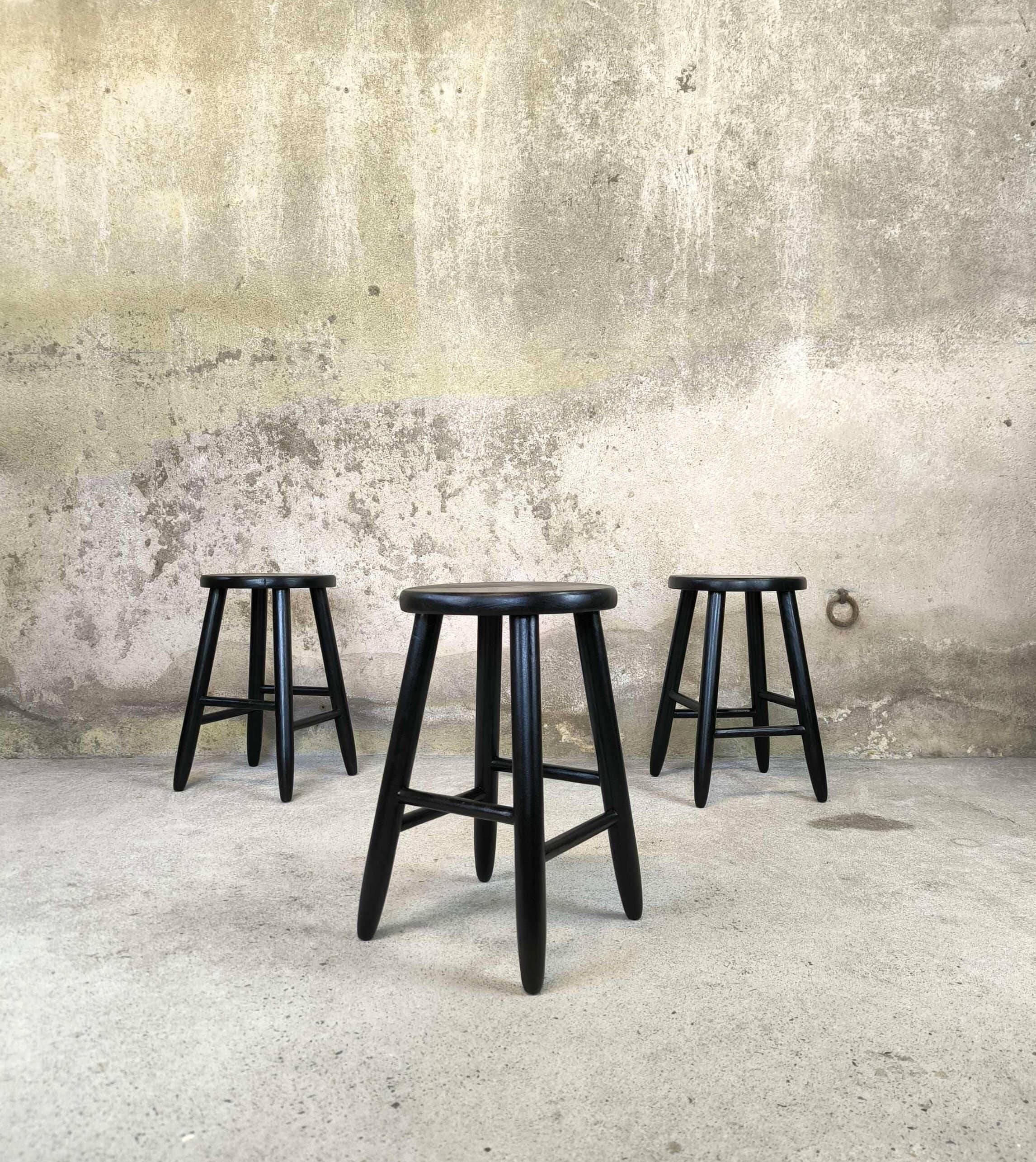 Set of three vintage stools in black lacquered wood.