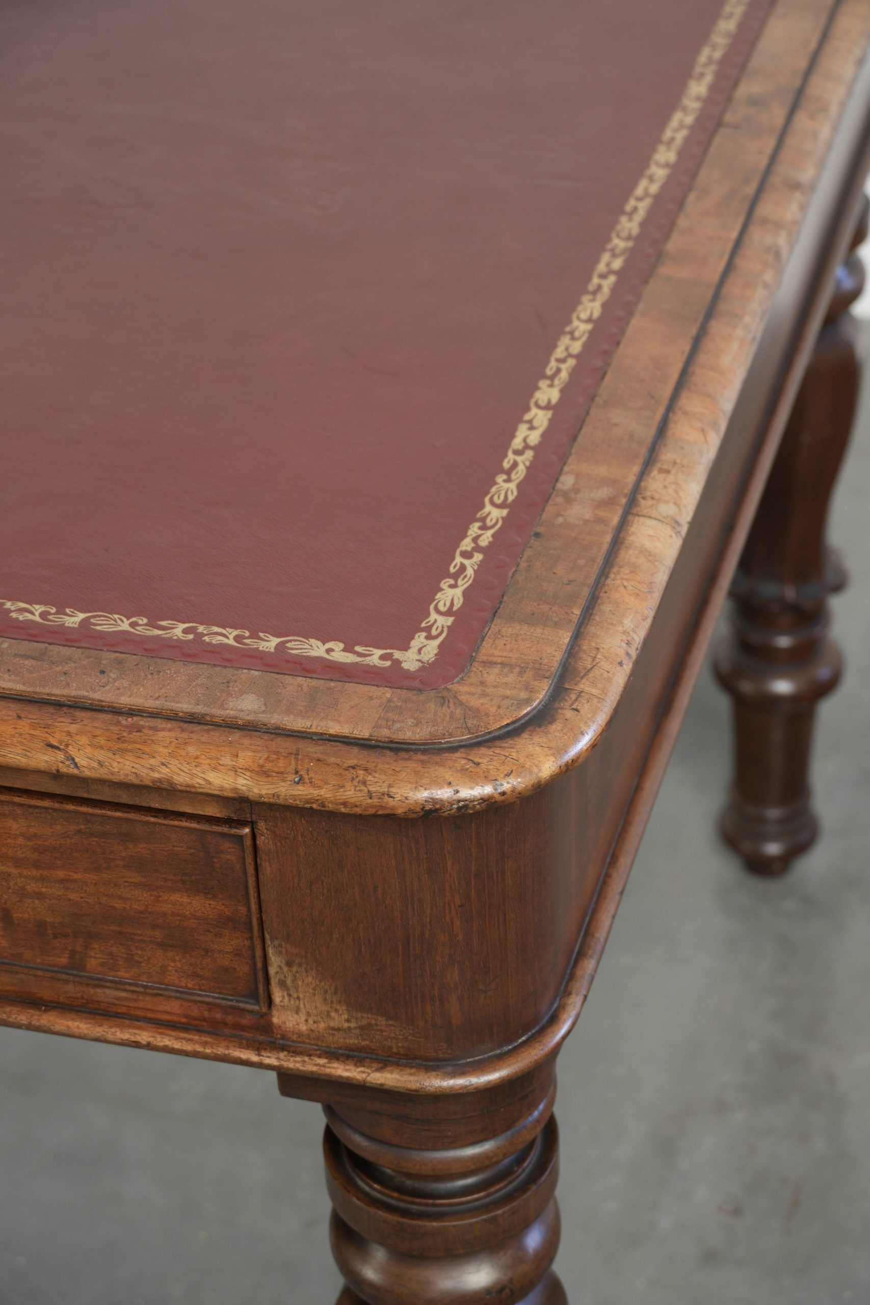 Antique English writing desk from the 19th century with a red leather top