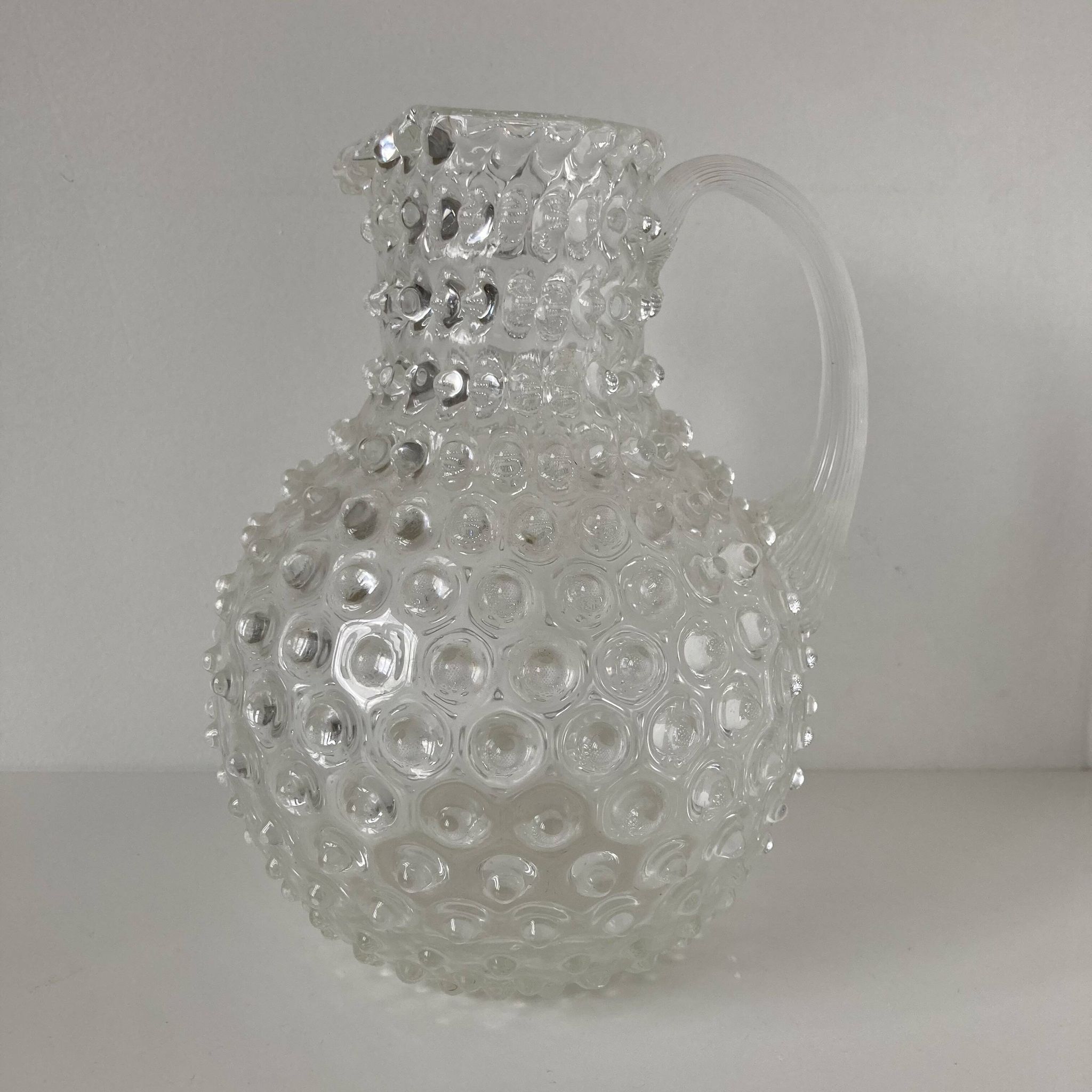 Beautiful and large vintage glass jug with a handle, made of clear hot-worked glass.