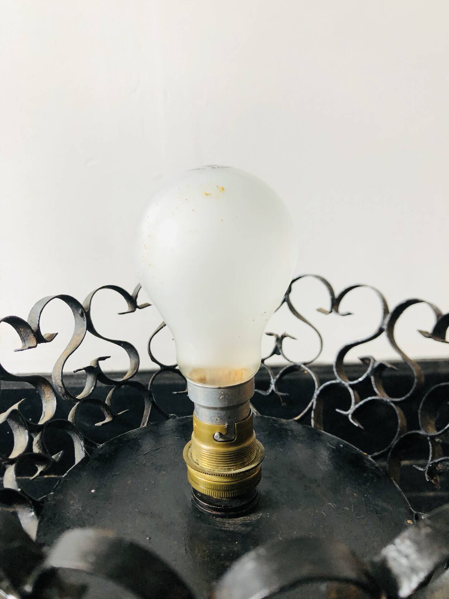 Handcrafted wrought iron lamp with a white opaline globe.