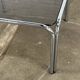 Table basse design vintage en verre fumé avec structure tubulaire